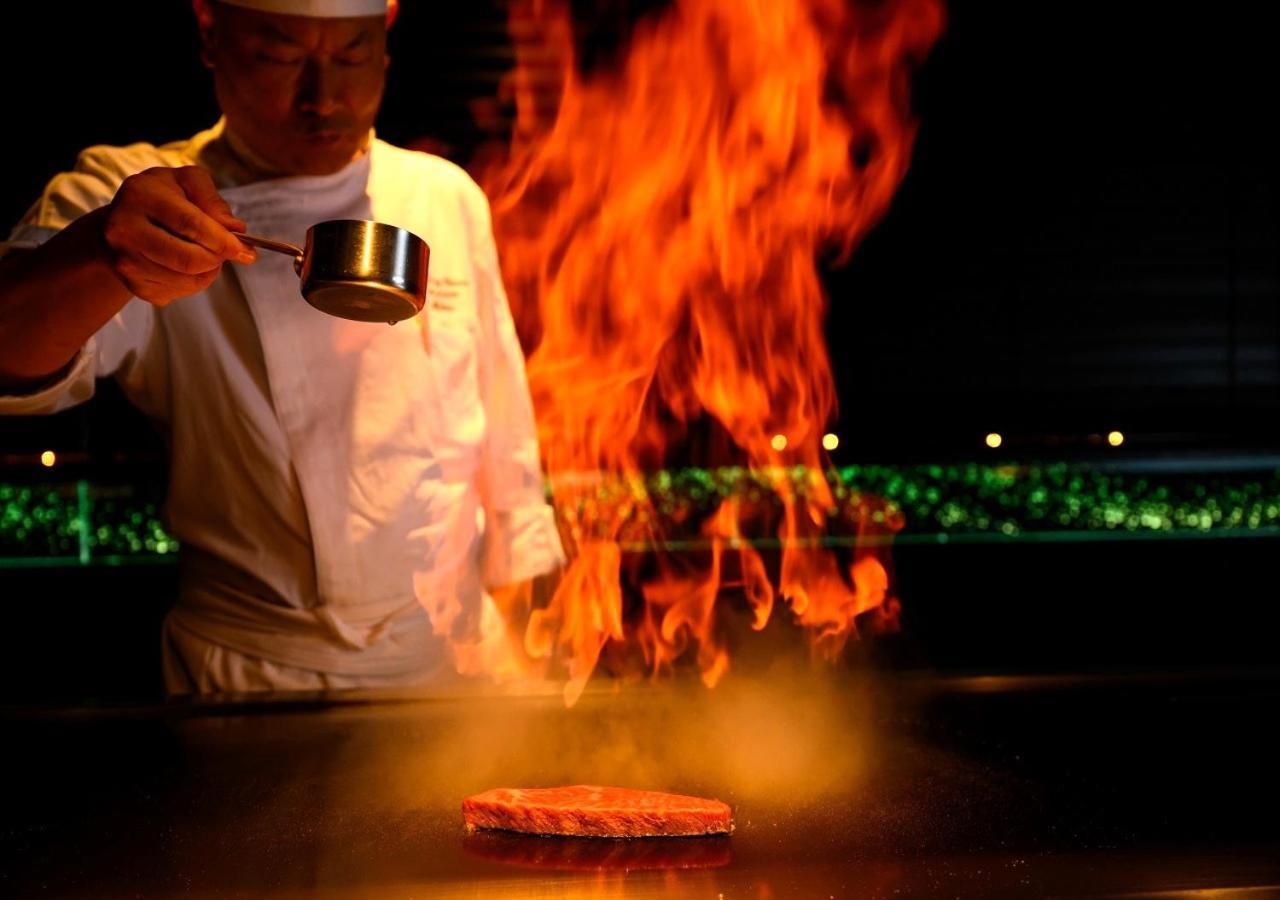 Hotel Monterey Okinawa Spa & Resort Onna Exterior photo A chef cooking with the technique of flambe